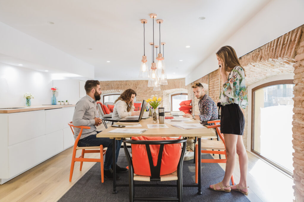 young-coworkers-gathering-table-office